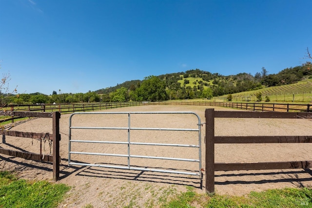 view of gate featuring a rural view, an enclosed area, and fence