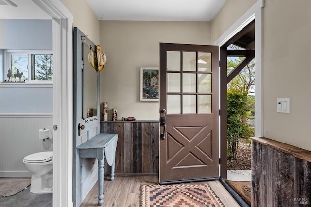 doorway featuring light wood-style flooring and a wainscoted wall