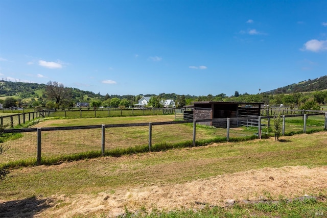 view of yard featuring an exterior structure, an outbuilding, and a rural view