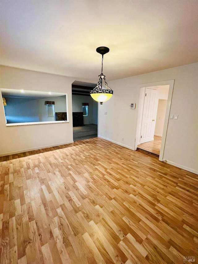 empty room with baseboards and light wood finished floors