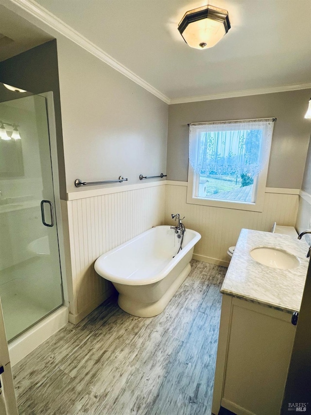 full bath with a stall shower, wainscoting, wood finished floors, and ornamental molding