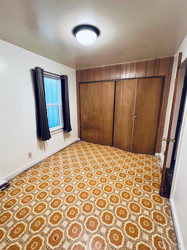 unfurnished bedroom with baseboards and a closet