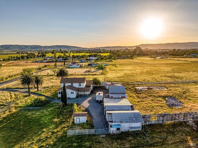 aerial view at dusk featuring a mountain view and a rural view