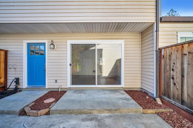 doorway to property featuring fence and a patio
