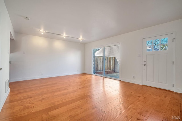 entryway featuring light wood-style flooring, baseboards, and visible vents