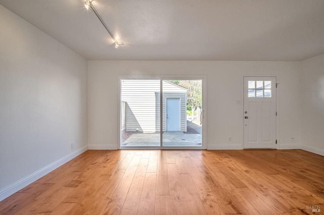 interior space with baseboards and light wood-style floors