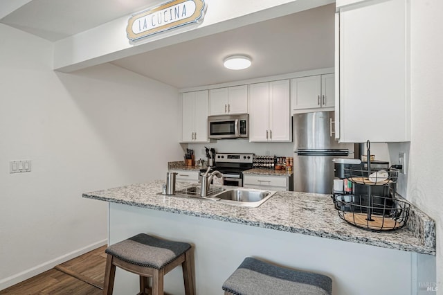 6482 Meadow Pines Ave, Rohnert Park, CA 94928 - kitchen with a kitchen breakfast bar, a sink, a peninsula, appliances with stainless steel finishes, and wood finished floors