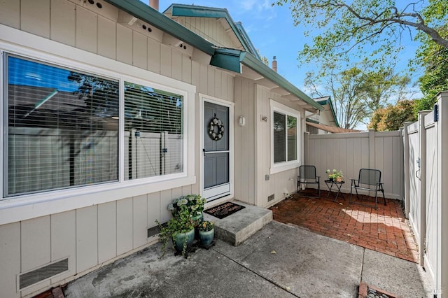 6482 Meadow Pines Ave, Rohnert Park, CA 94928 - view of exterior entry featuring fence, visible vents, a patio, crawl space, and board and batten siding
