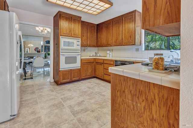 271 Antigua Way, Vallejo, CA 94591 - kitchen featuring white appliances, a chandelier, tasteful backsplash, brown cabinetry, and tile counters