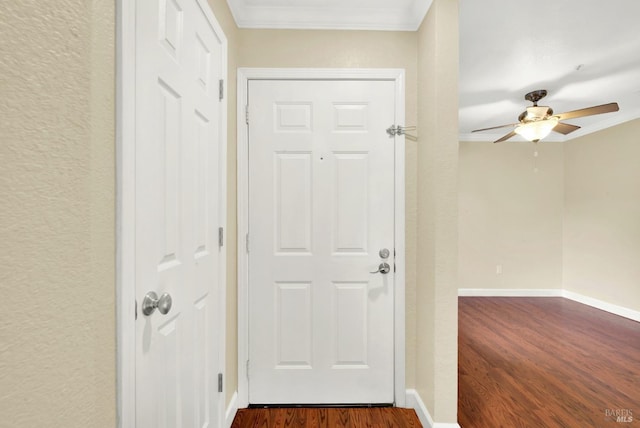 entryway featuring ceiling fan, baseboards, ornamental molding, and dark wood finished floors