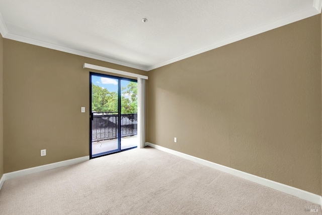 empty room with light carpet, crown molding, and baseboards