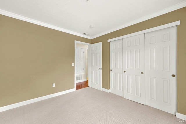 unfurnished bedroom featuring crown molding, visible vents, and carpet