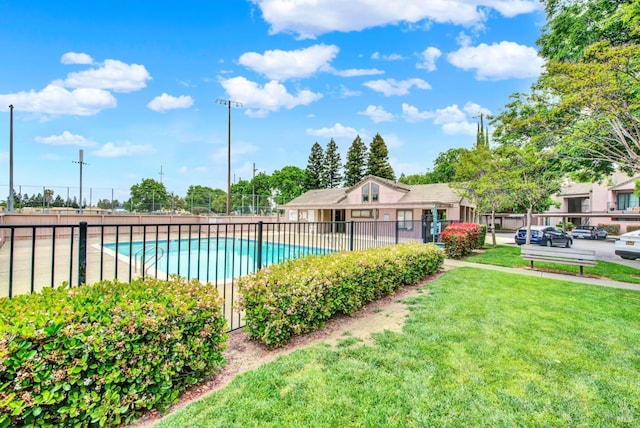 community pool featuring fence and a yard