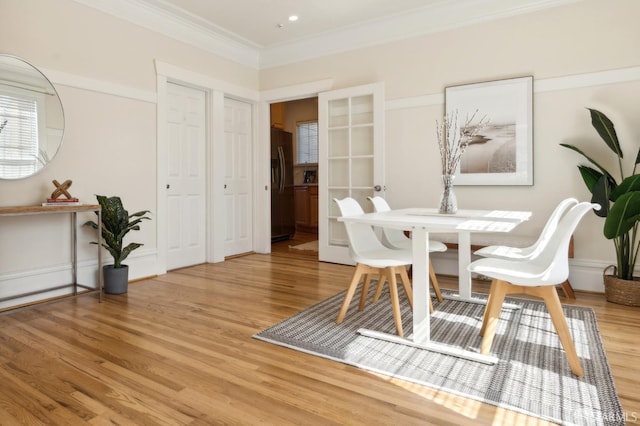 dining room featuring crown molding and light wood-style floors