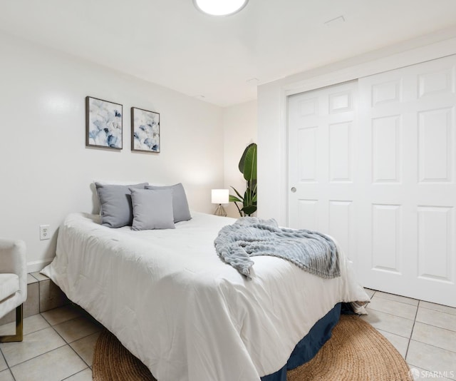 bedroom with light tile patterned floors and a closet