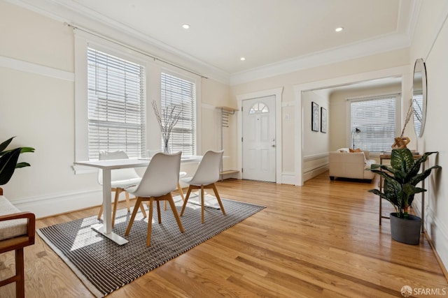 dining area featuring light wood-type flooring, ornamental molding, baseboards, and a wealth of natural light