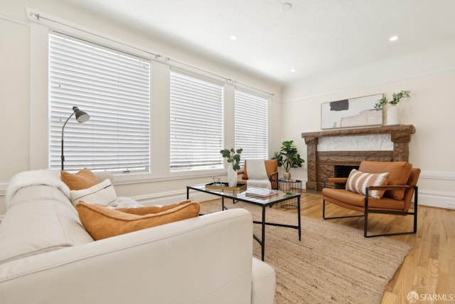 living area featuring recessed lighting, light wood finished floors, and a fireplace