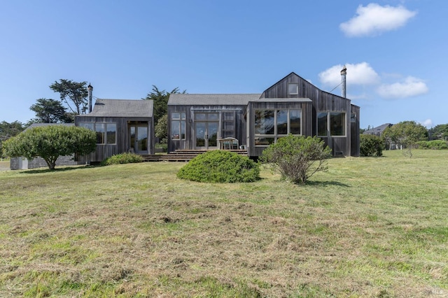 rear view of house featuring a wooden deck and a yard