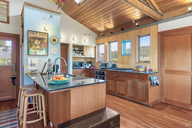 kitchen with lofted ceiling, a sink, light wood-style floors, and wooden ceiling
