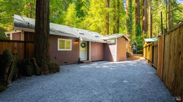 view of front of home featuring crawl space, roof with shingles, and fence