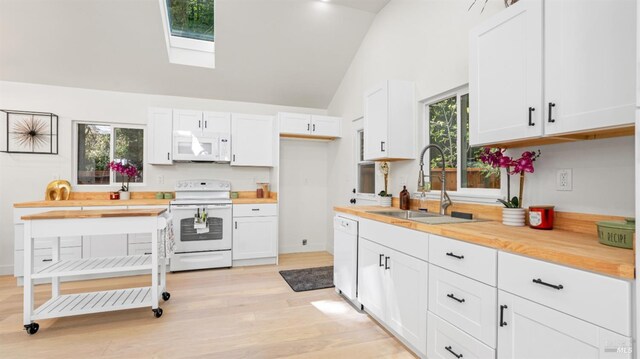 kitchen with a sink, white cabinetry, and white appliances