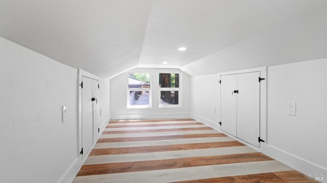 bonus room with recessed lighting, light wood-style floors, and vaulted ceiling
