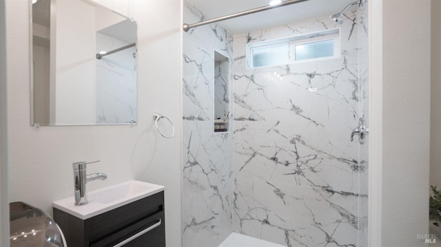 bathroom featuring vanity and a marble finish shower