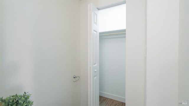hall with light wood-style floors and baseboards