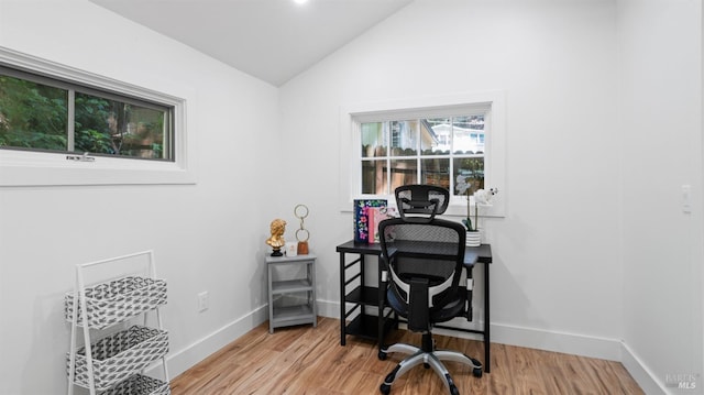home office with light wood-type flooring, baseboards, and lofted ceiling