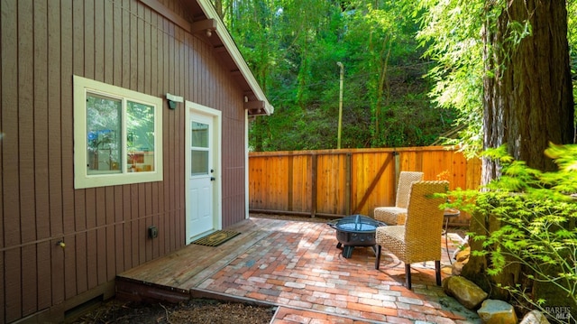view of patio featuring fence and a fire pit