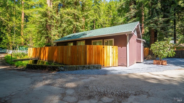 exterior space featuring a wooded view and fence