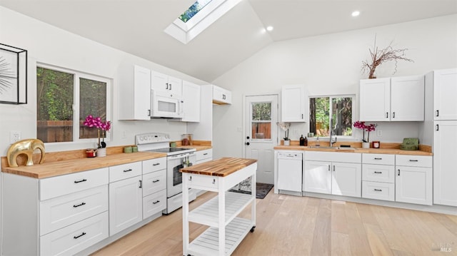 kitchen featuring white appliances, light wood-style floors, a sink, and butcher block countertops