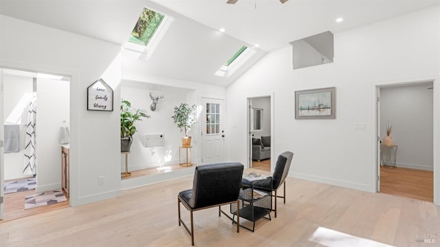 dining room featuring light wood-type flooring, a ceiling fan, recessed lighting, a skylight, and high vaulted ceiling