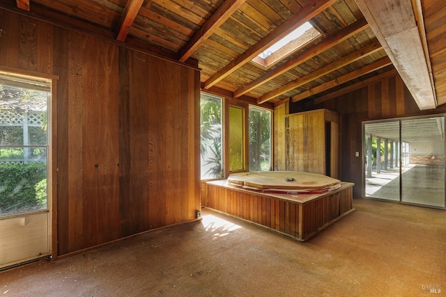 bathroom with wood walls, vaulted ceiling with skylight, and plenty of natural light