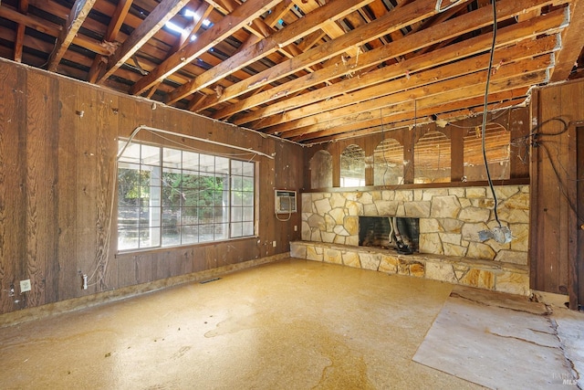 basement featuring visible vents, a stone fireplace, and a wall mounted AC