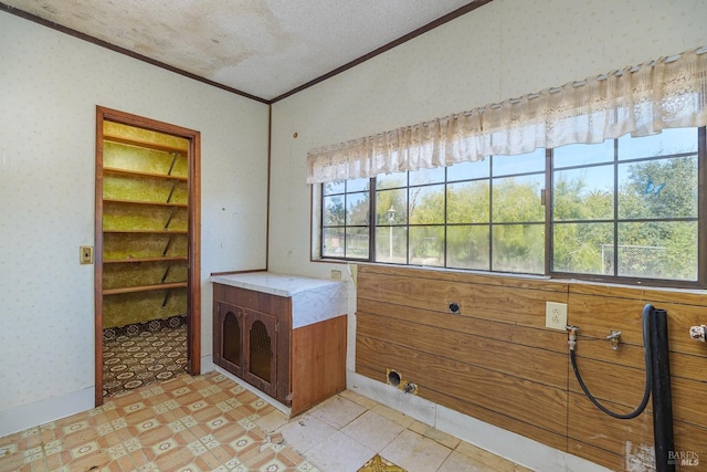 interior space with crown molding, wallpapered walls, and a textured ceiling