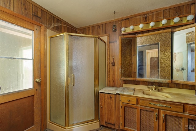 bathroom with wooden walls, vanity, and a stall shower