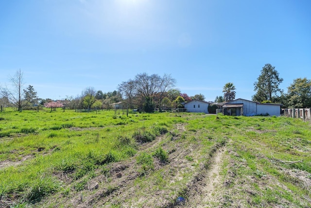 view of yard with a rural view and fence