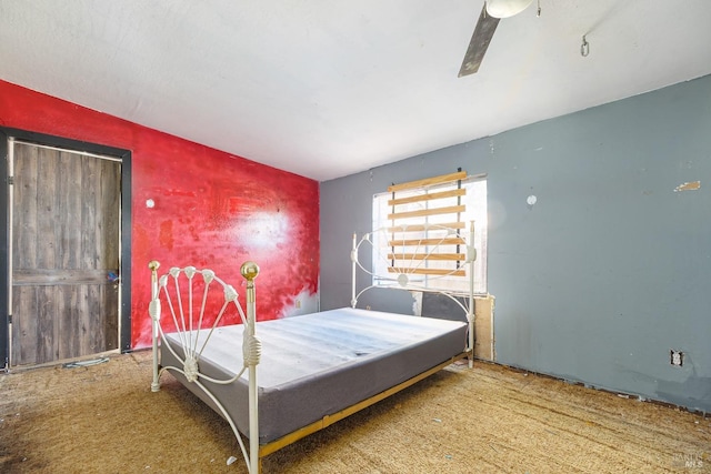 bedroom with ceiling fan and an accent wall