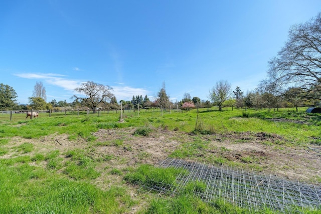 view of yard with a rural view and fence