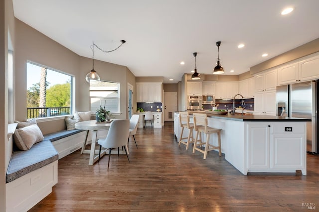 146 Shelina Vista Ln, Petaluma, CA 94952 - kitchen with white cabinets, appliances with stainless steel finishes, dark countertops, decorative light fixtures, and decorative backsplash