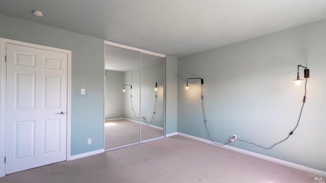 unfurnished bedroom with a closet, baseboards, and carpet