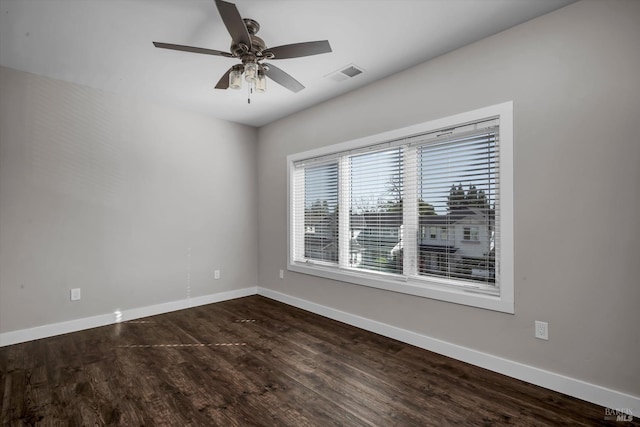 unfurnished room with visible vents, dark wood-style flooring, and baseboards