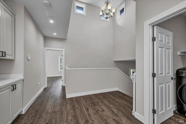interior space with a chandelier, baseboards, recessed lighting, dark wood-type flooring, and a high ceiling