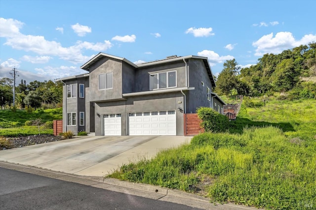view of front of property featuring stucco siding, driveway, and an attached garage