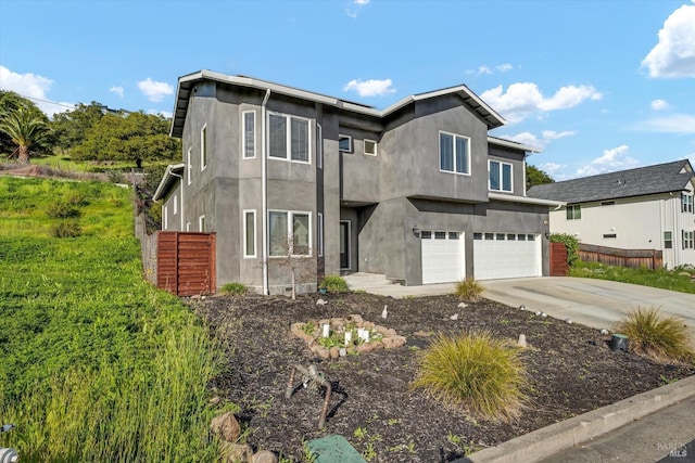 traditional-style home featuring concrete driveway, stucco siding, an attached garage, and fence