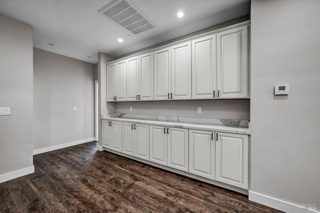 kitchen featuring visible vents, baseboards, white cabinetry, light countertops, and dark wood finished floors