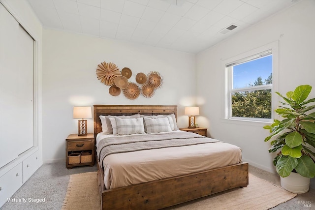 bedroom featuring carpet floors, visible vents, and baseboards