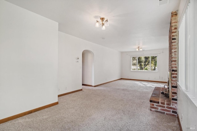 unfurnished living room featuring arched walkways, carpet floors, visible vents, and baseboards