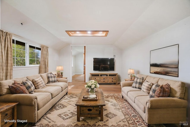 living area with vaulted ceiling and light wood-style floors